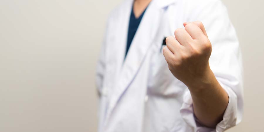医学部進学を目指す学生や医師の志を象徴する画像。白衣姿の人物が拳を握っている