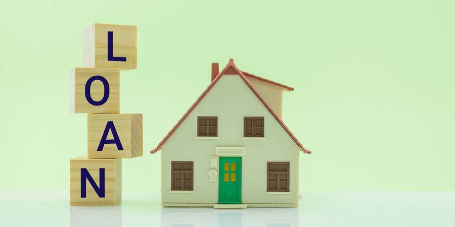 不動産担保ローンをイメージした住宅模型と「LOAN」の文字ブロックの画像
