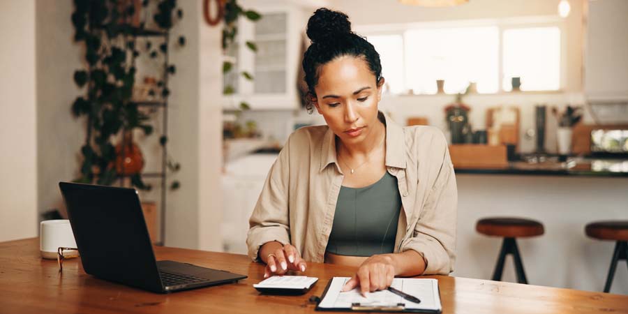 個人事業主がノートと電卓を使ってビジネスローンの金利を比較検討しているイメージ画像