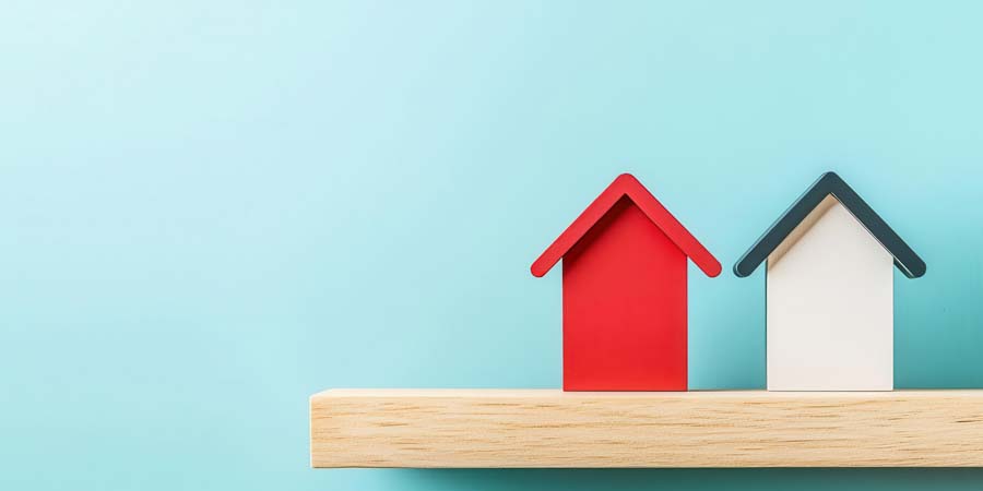 赤と白の家の模型が並ぶ様子。不動産担保ローンの選択や比較を表す画像