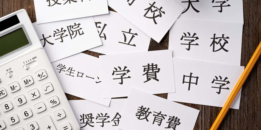 教育費や学費を示すカードと電卓が並ぶ写真