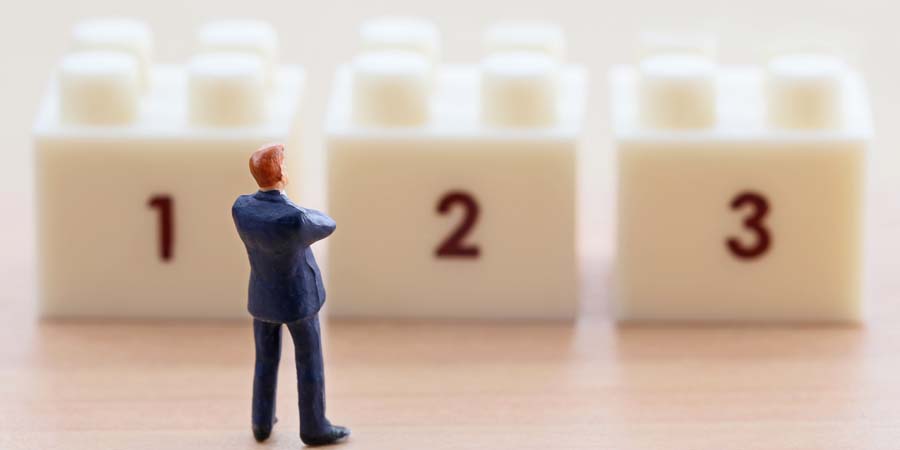 数字のブロックを前に別の資金調達方法を考える人物のイメージ写真