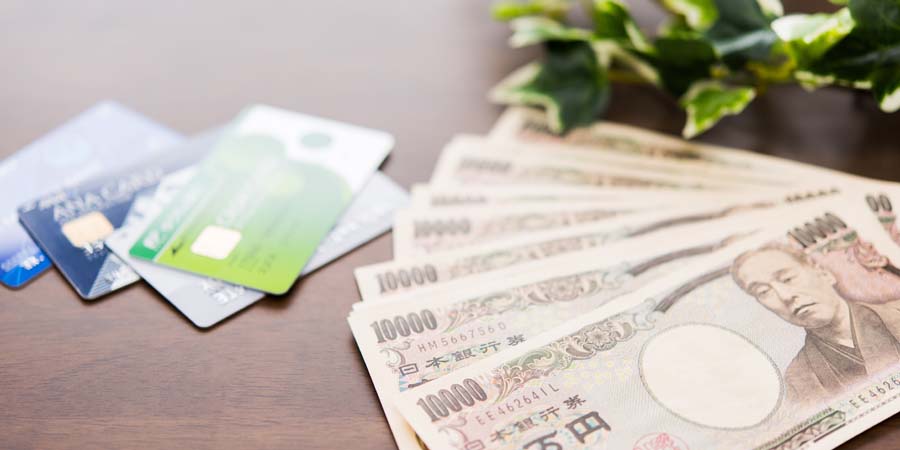 現金とクレジットカードが並べられ、多様な資金調達手段をイメージした画像