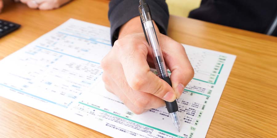 不動産担保ローンの申込書を確認しながら注意点をチェックしているイメージ画像